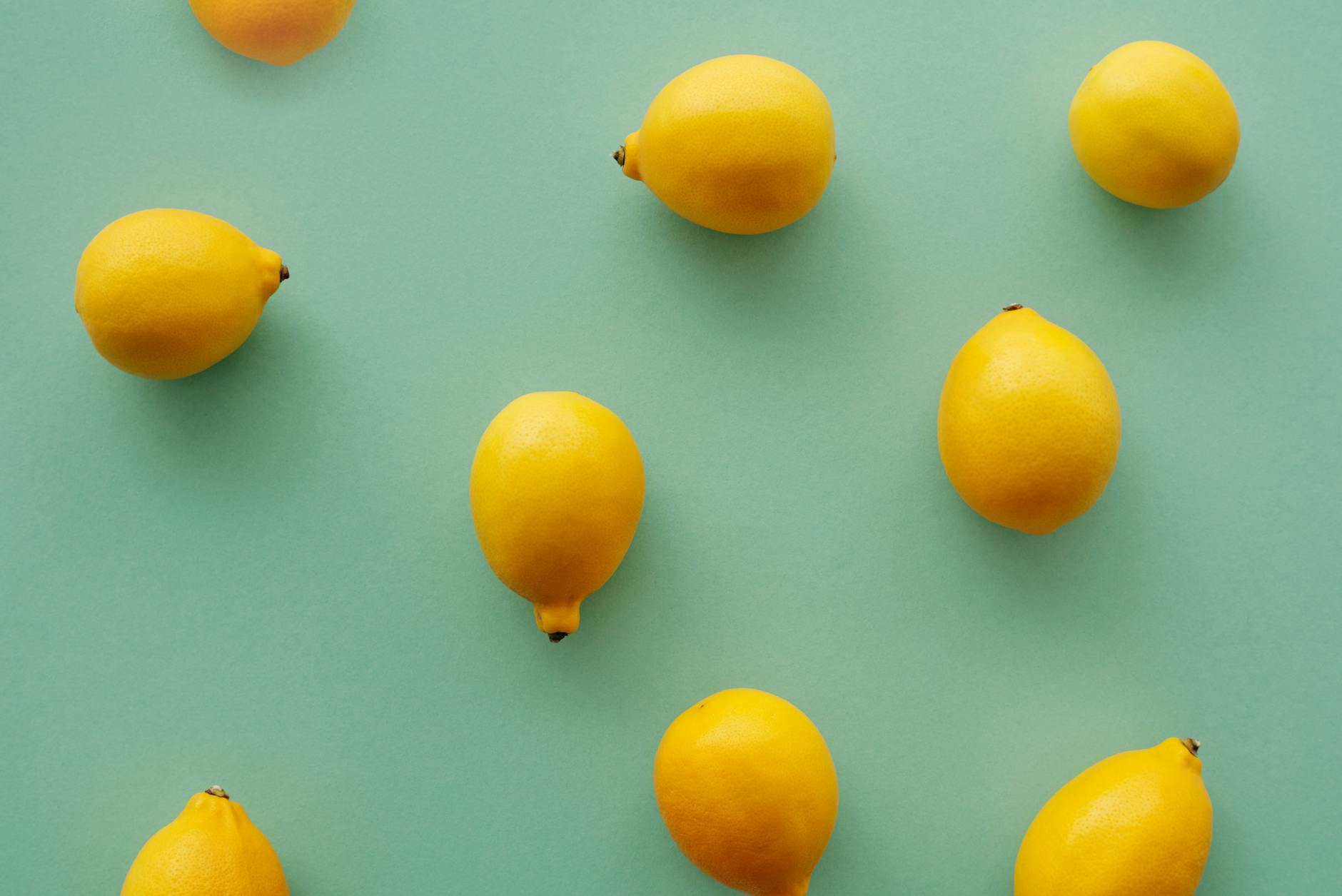 Limoni freschi e vibranti su uno sfondo verde pastello che rappresentano la freschezza e la vitalità