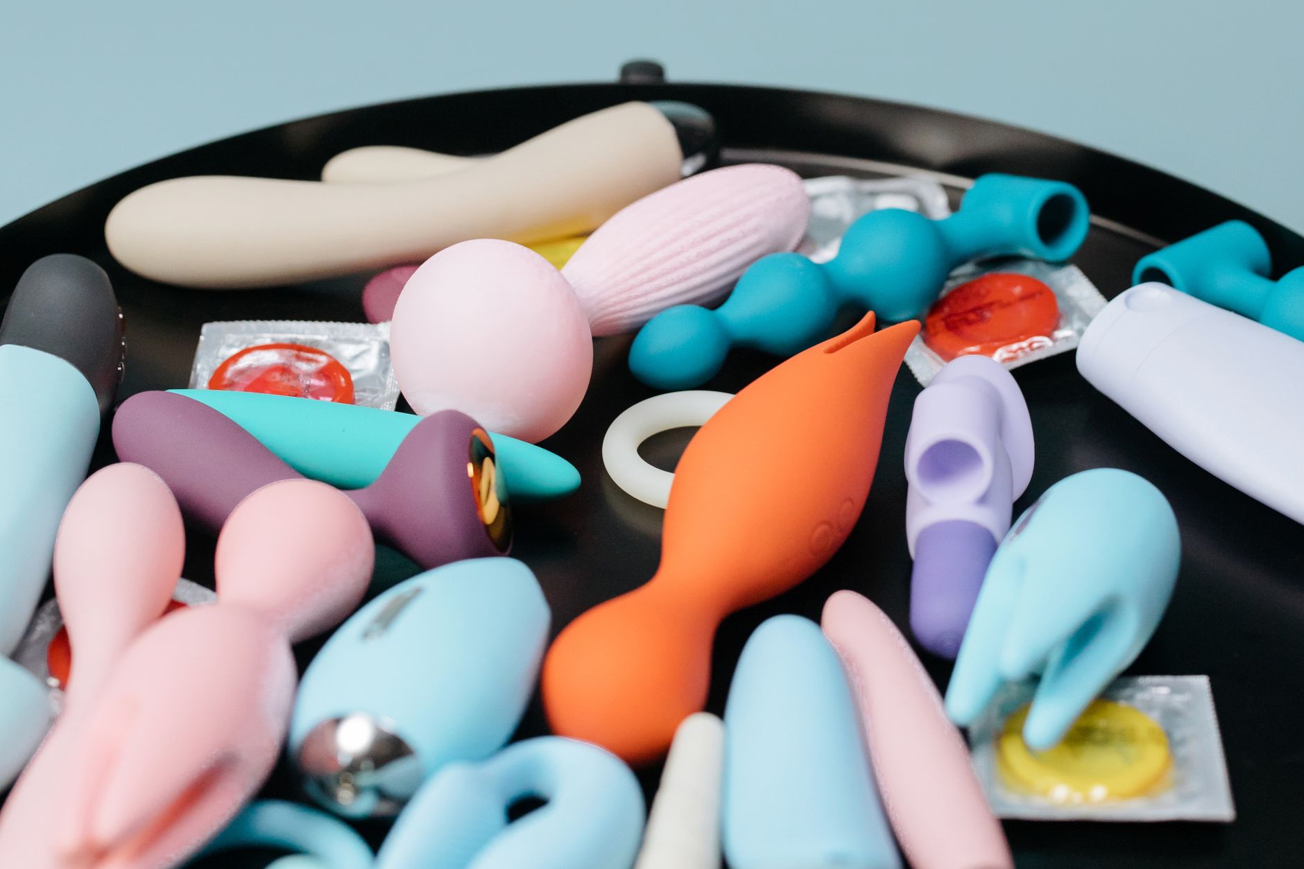 Hands holding pastel-colored silicone toys, representing the sensory experience of lemon clitoral vibrators