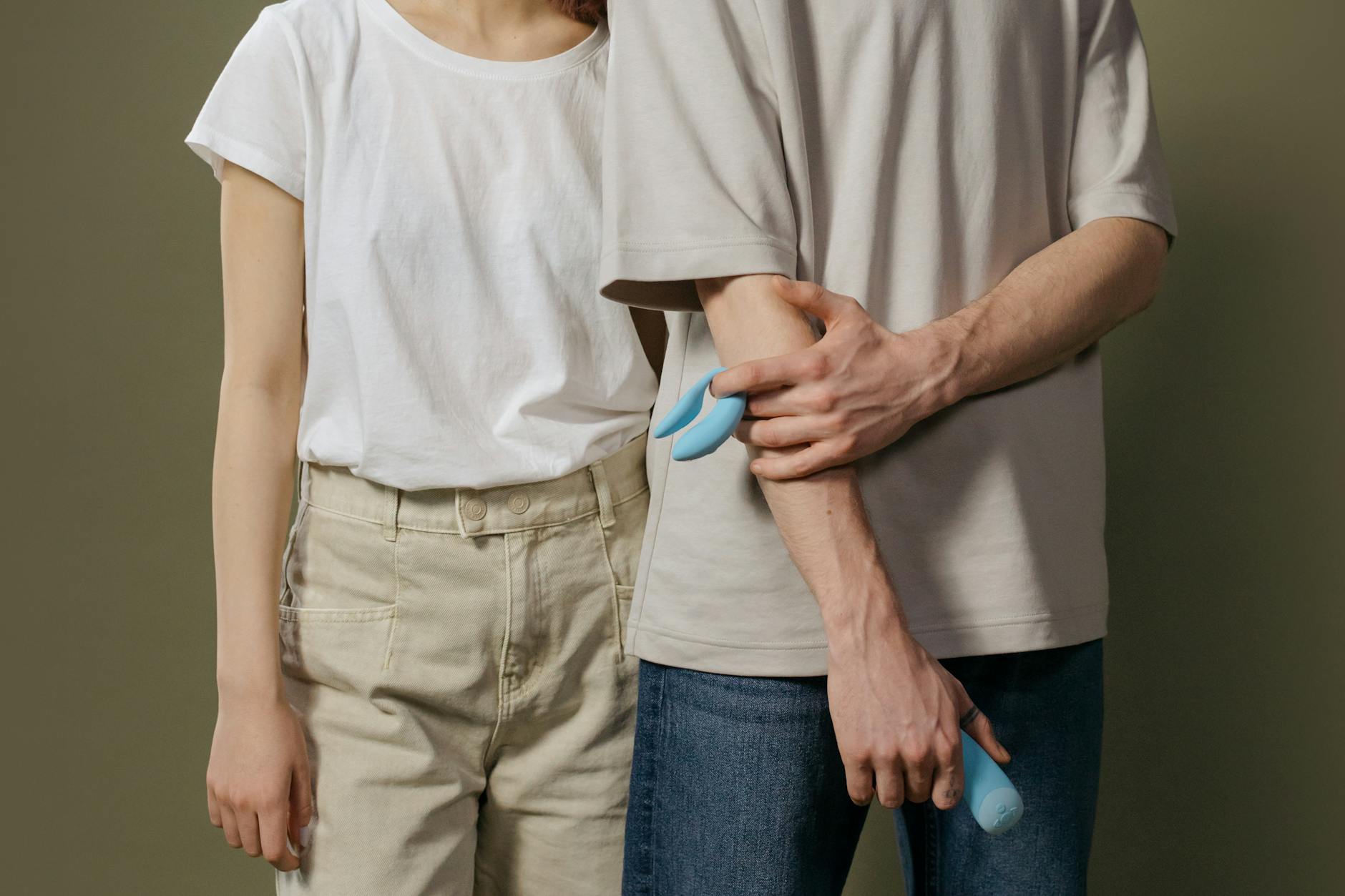 Woman holding blue and pink silicone vibrators, representing different pleasure responses on hormonal birth control